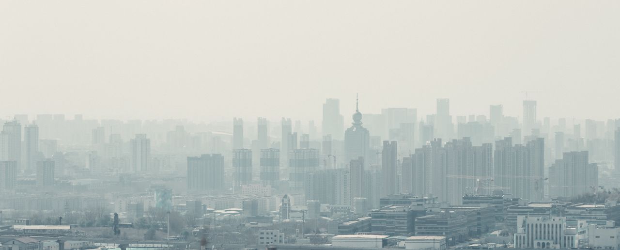 Vue aérienne de la ligne d'horizon de la ville de Zibo avec des gratte-ciel modernes sous un ciel brumeux